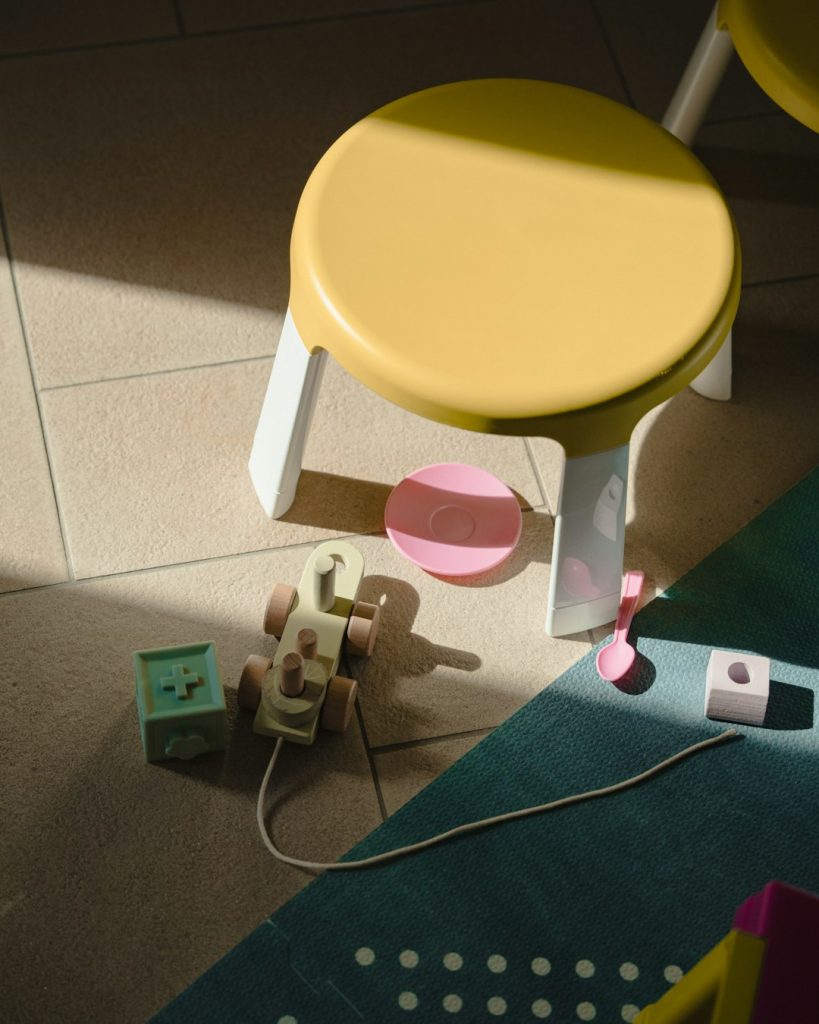 a-yellow-chair-with-a-pink-plastic-cup-and-a-green-plastic-container-qglll0njlw0